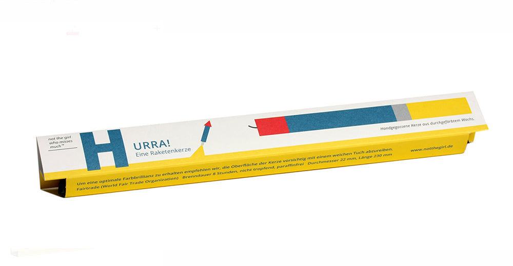 Verpakking van speciale kerst-kaarsen, langwerpige doos in geel met blauw-rood motief.