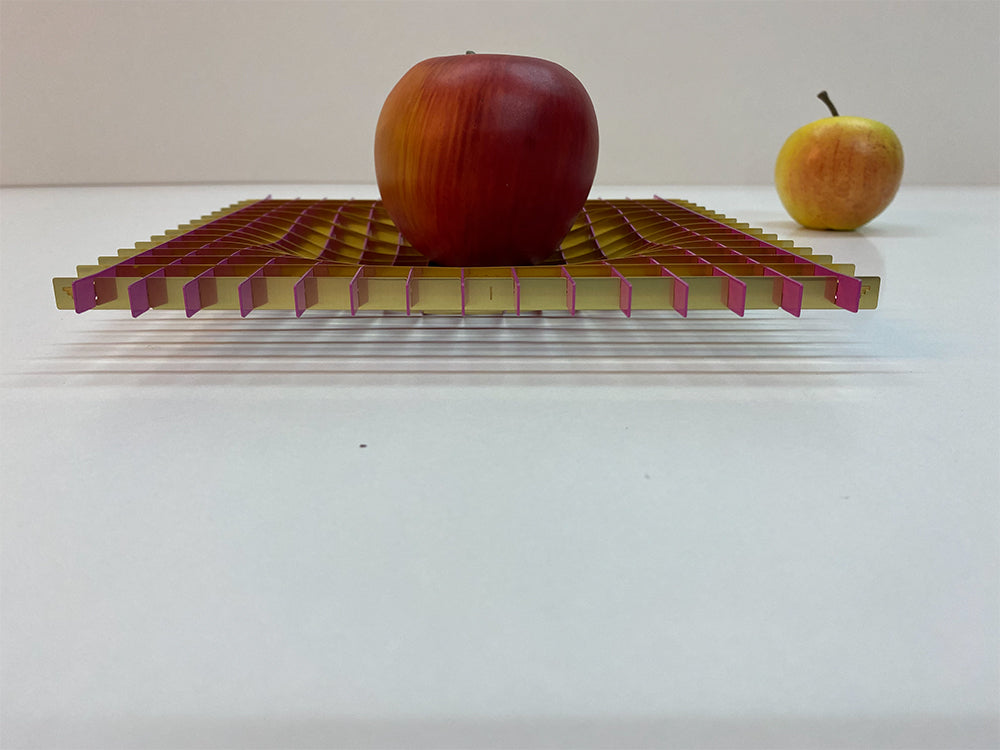 Metalen fruitschaal Gravity in goud en magenta, schuin vooraanzicht