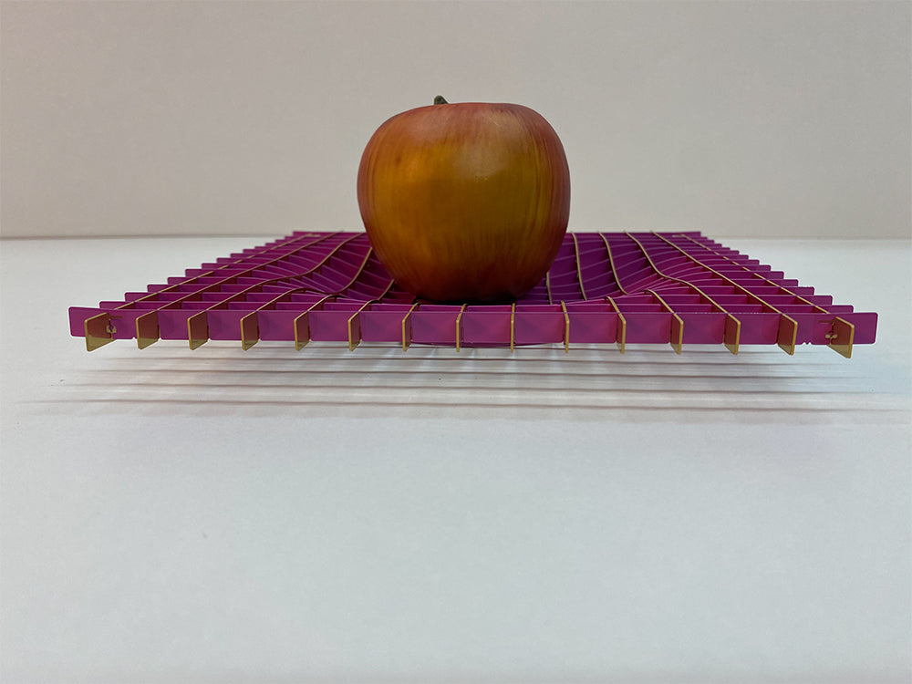 Fundamental Gravity fruitschaal in magenta, detail met appel op golvend patroon
