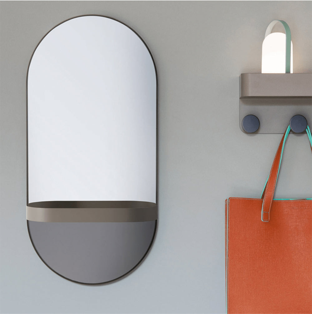 Spiegel van taupe staal aan de wand naast wandgarderobe met haken