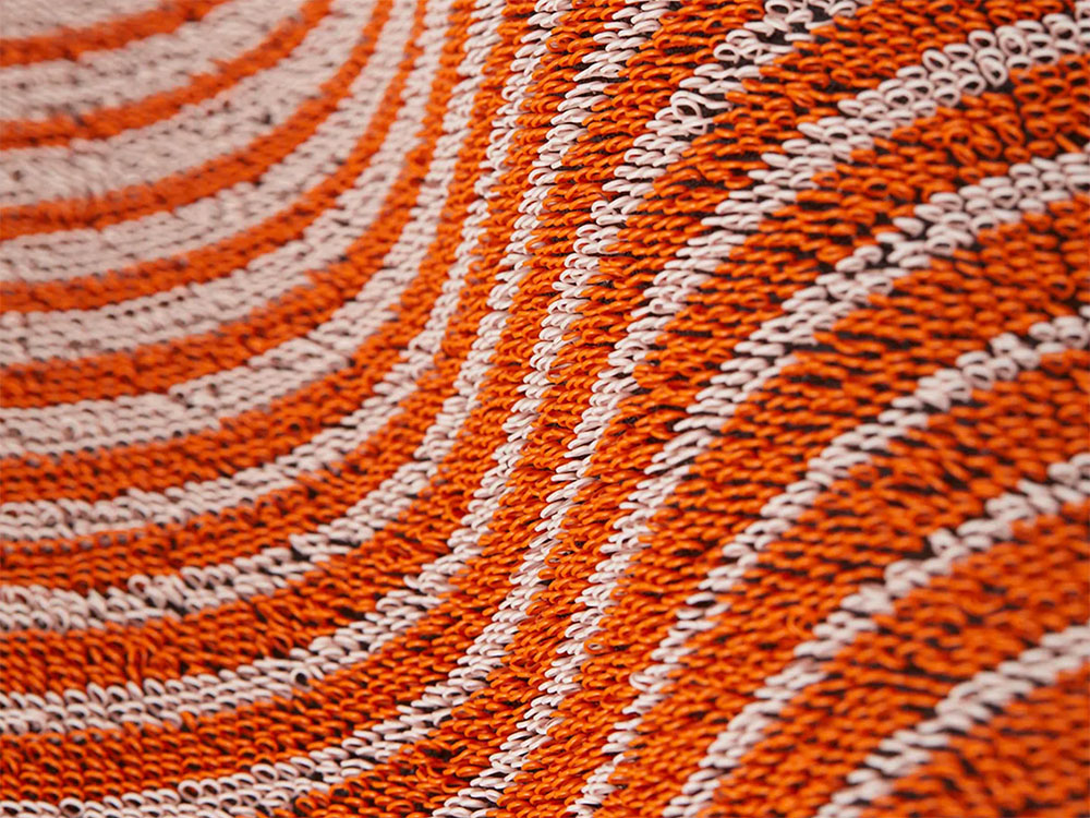 Detail van het geweven streepmotief van de deurmat Domino-Apricot in oranje en wit