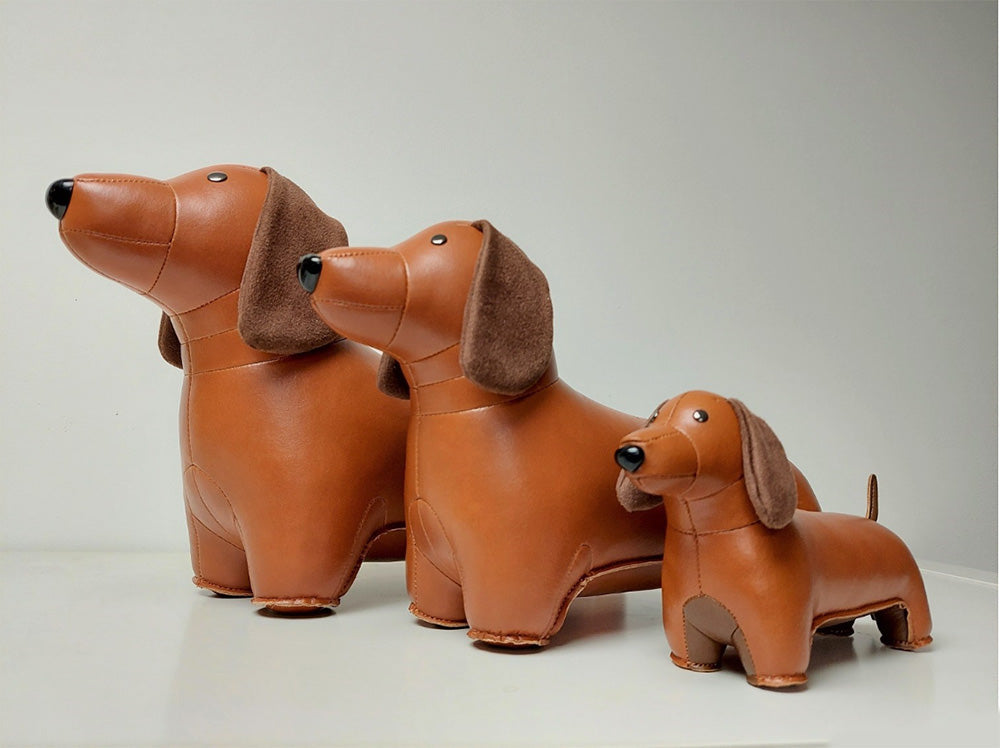 Zuny teckel paperweight in bruin, naast twee grotere formaten