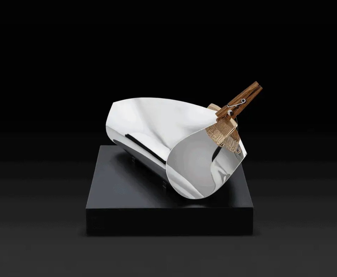 Obget Inutile van Salvador Dali voor Alessi, sculptuur in glanzend staal op zwart voetstuk.