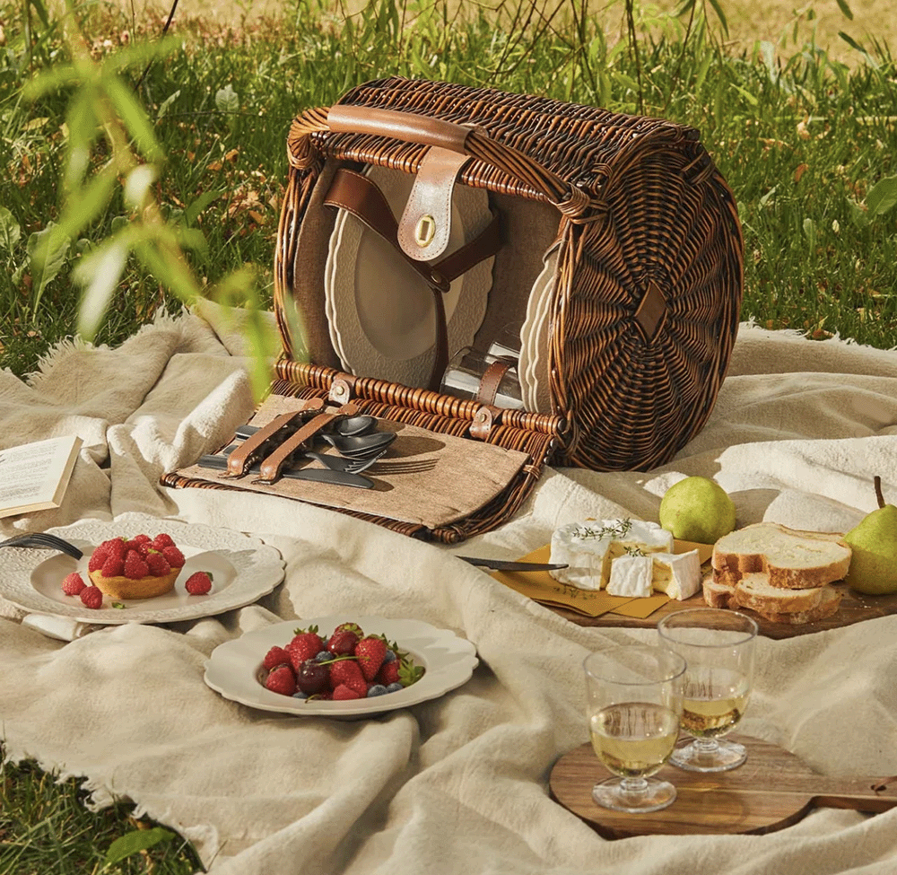 Rieten picknickmand Dressed van Alessi, geopend met borden, bestek en glazen