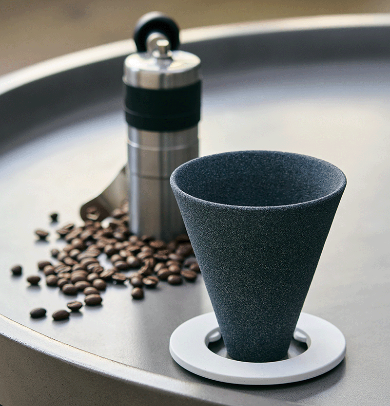 Cerapotta ceramic coffee filter next to coffee beans and a coffee grinder