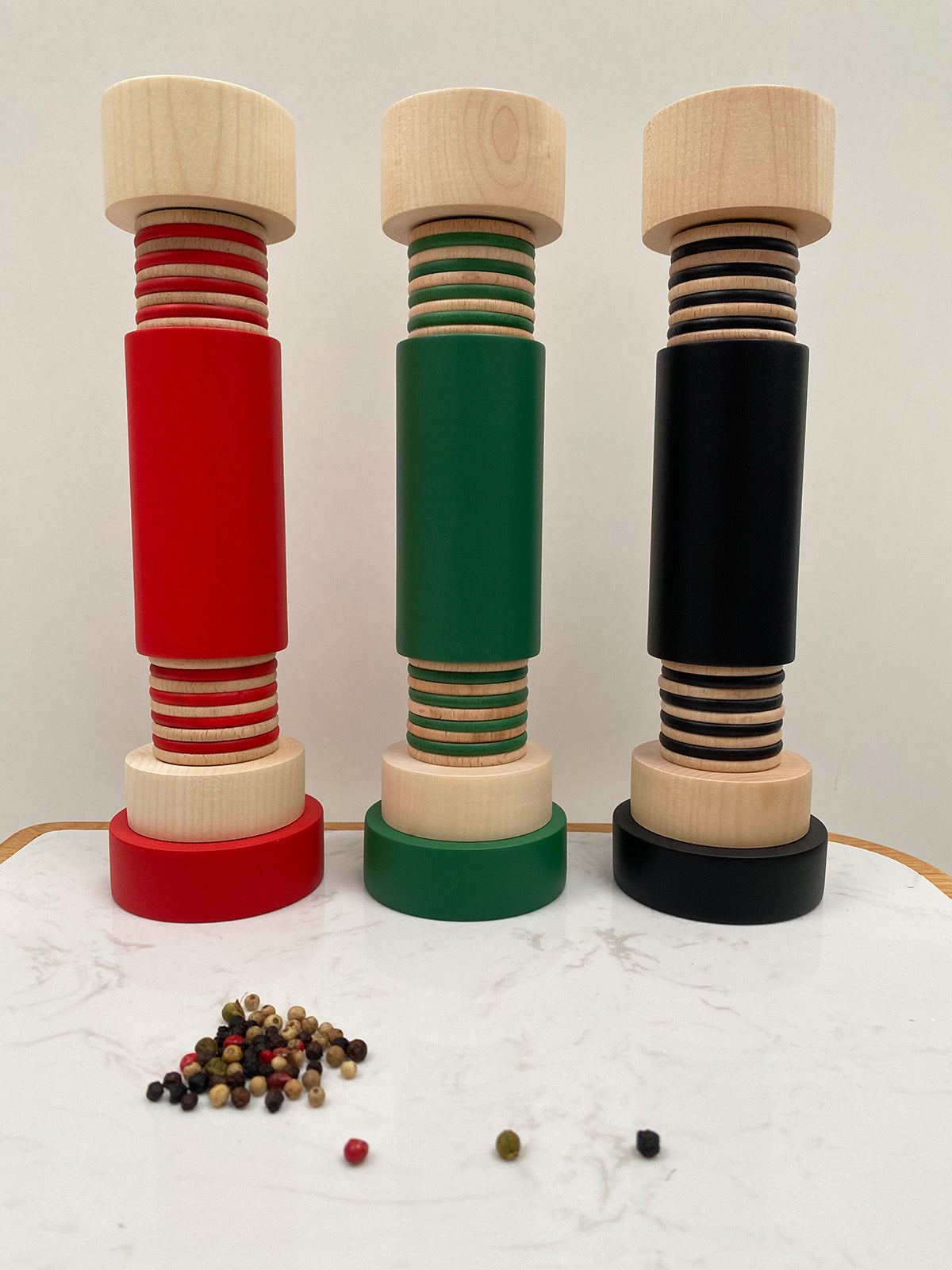 Twergi pepper mills in red, green and black side by side on table