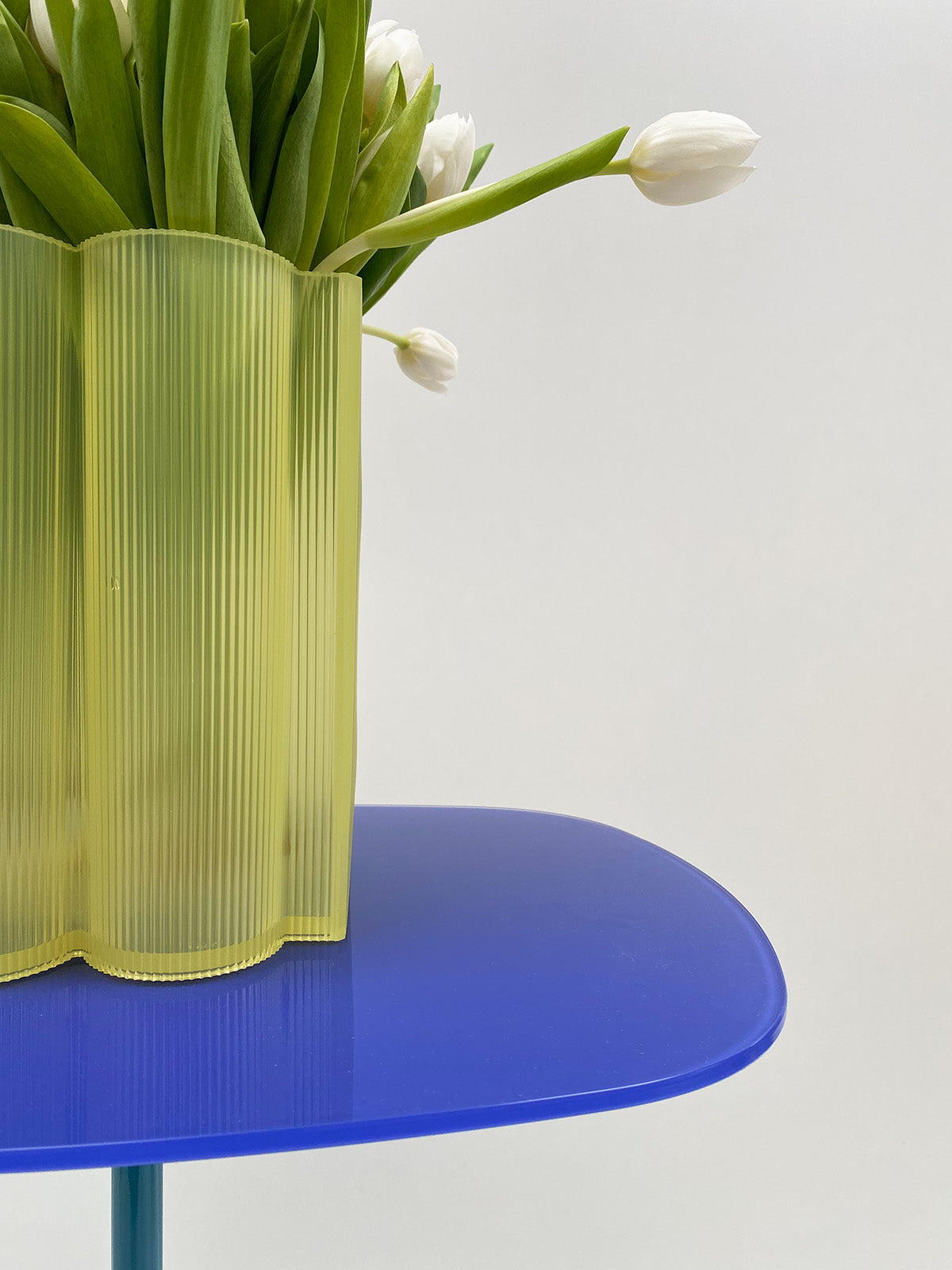 Detail van de vaas Okra Laag van Kartell in geel, met witte tulpen