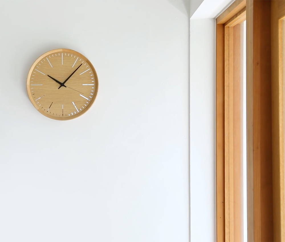 Lemnos Fluct Naturel wandklok in eiken, ontwerp Daisuke Kitagawe, aan de wand