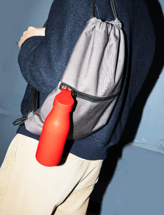 Alessi Away thermobeker rood met clip aan een rugzak, in gebruik