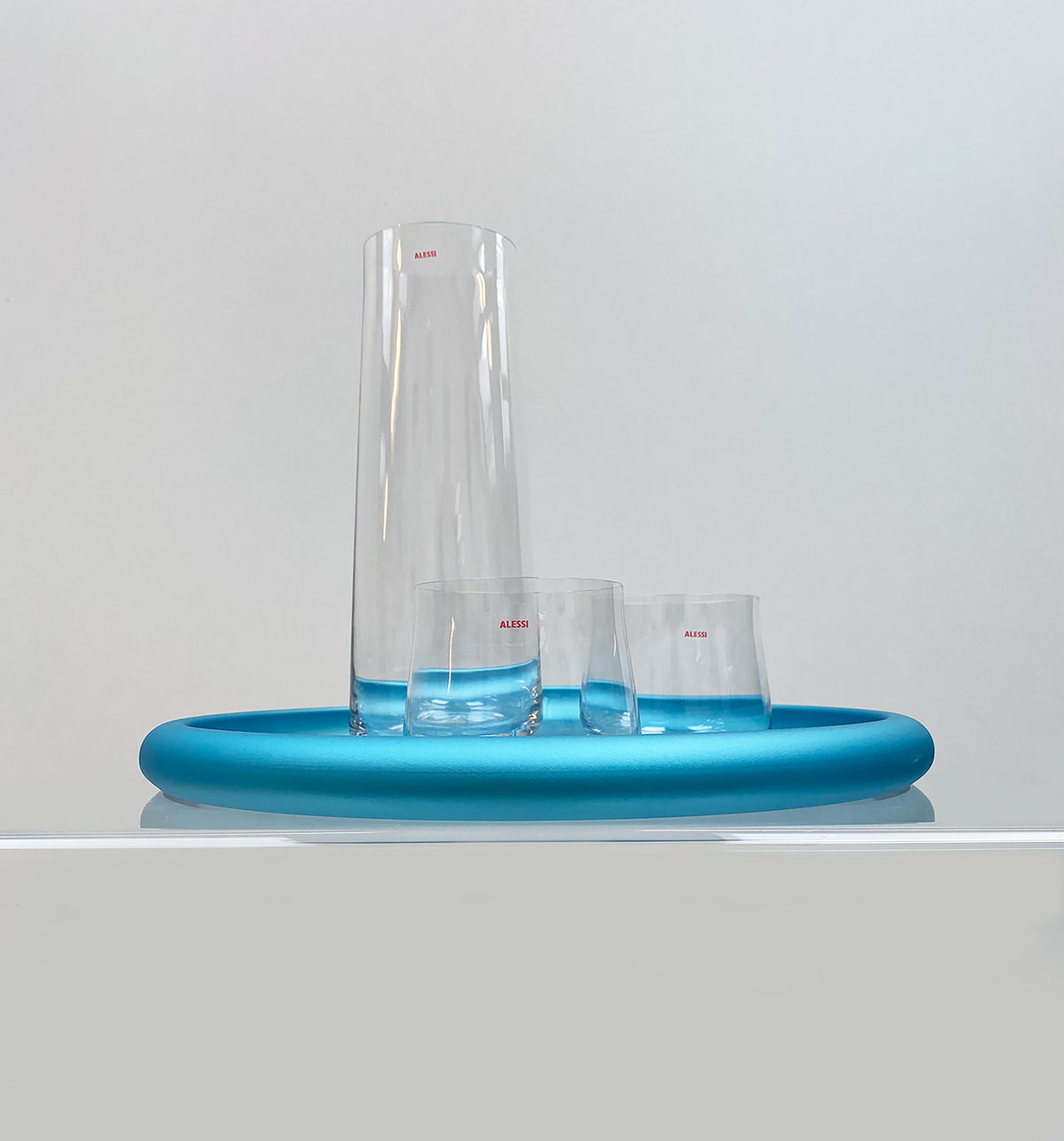 Eugenia carafe and two glasses on blue tray, top view