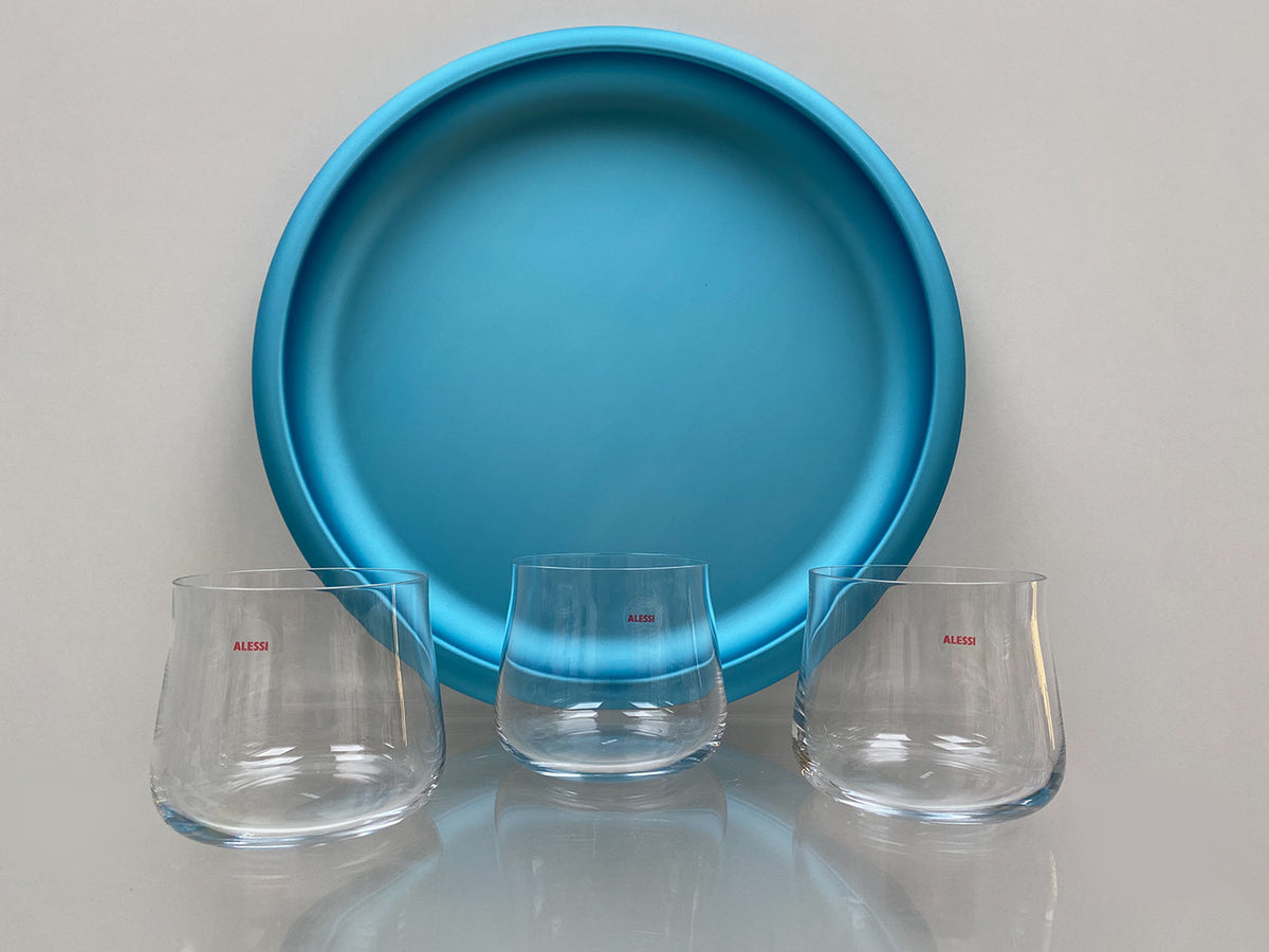 Alessi Eugenia waterglazen, drie stuks naast blauw dienblad van nieuwe glas-servies