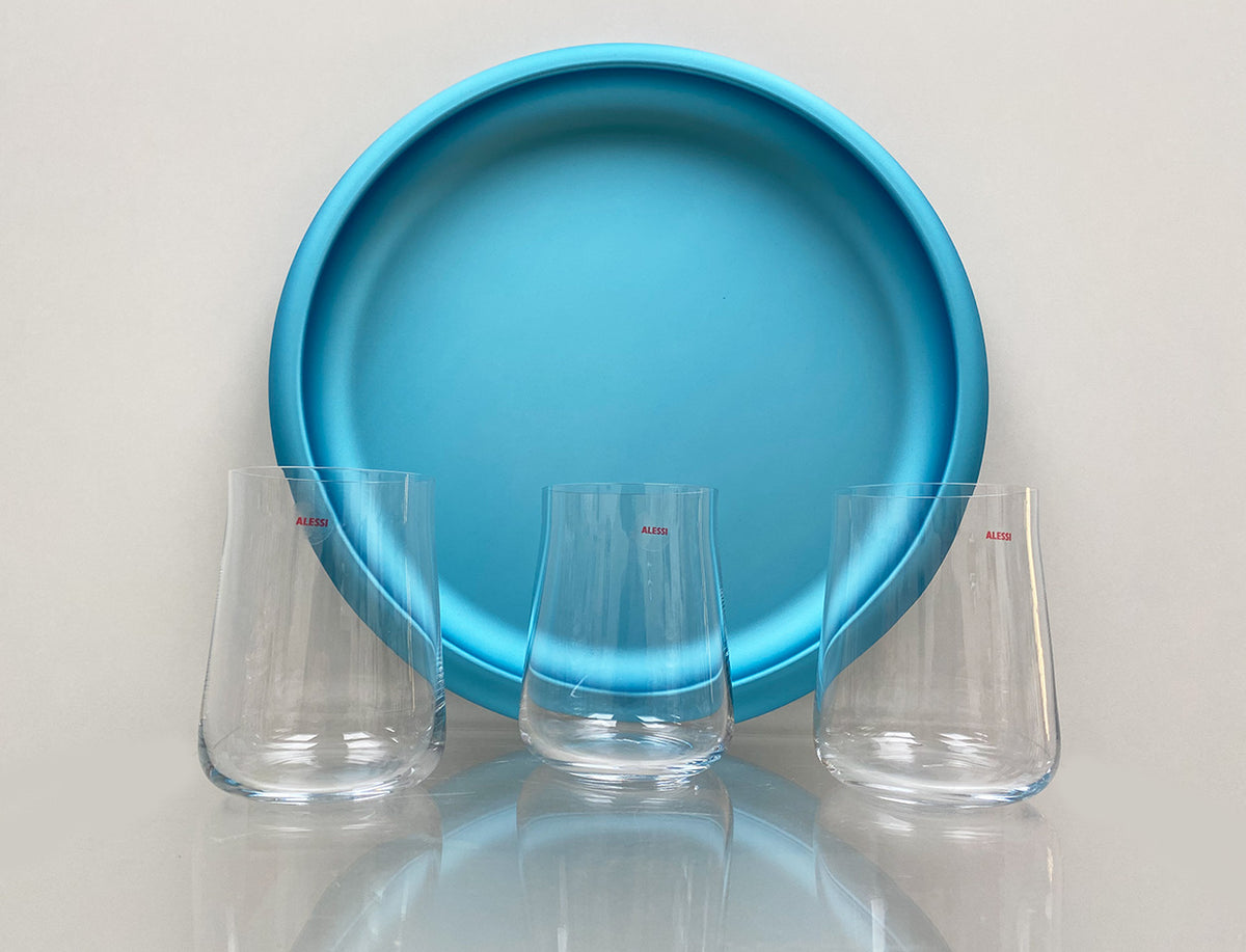 Alessi Eugenia highball glasses, three pieces next to a blue tray