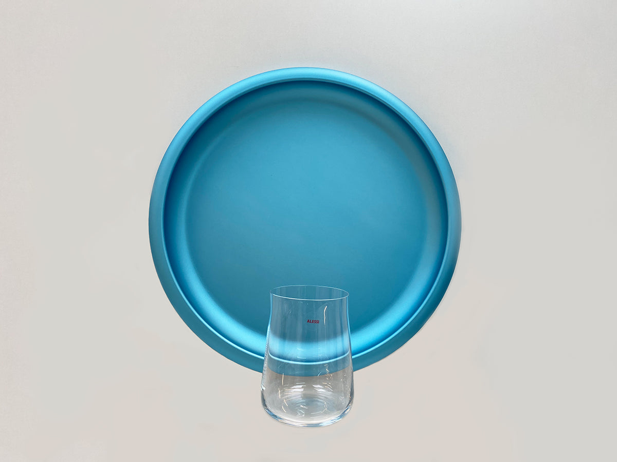 Alessi Eugenia longdrink glass next to blue tray, top view