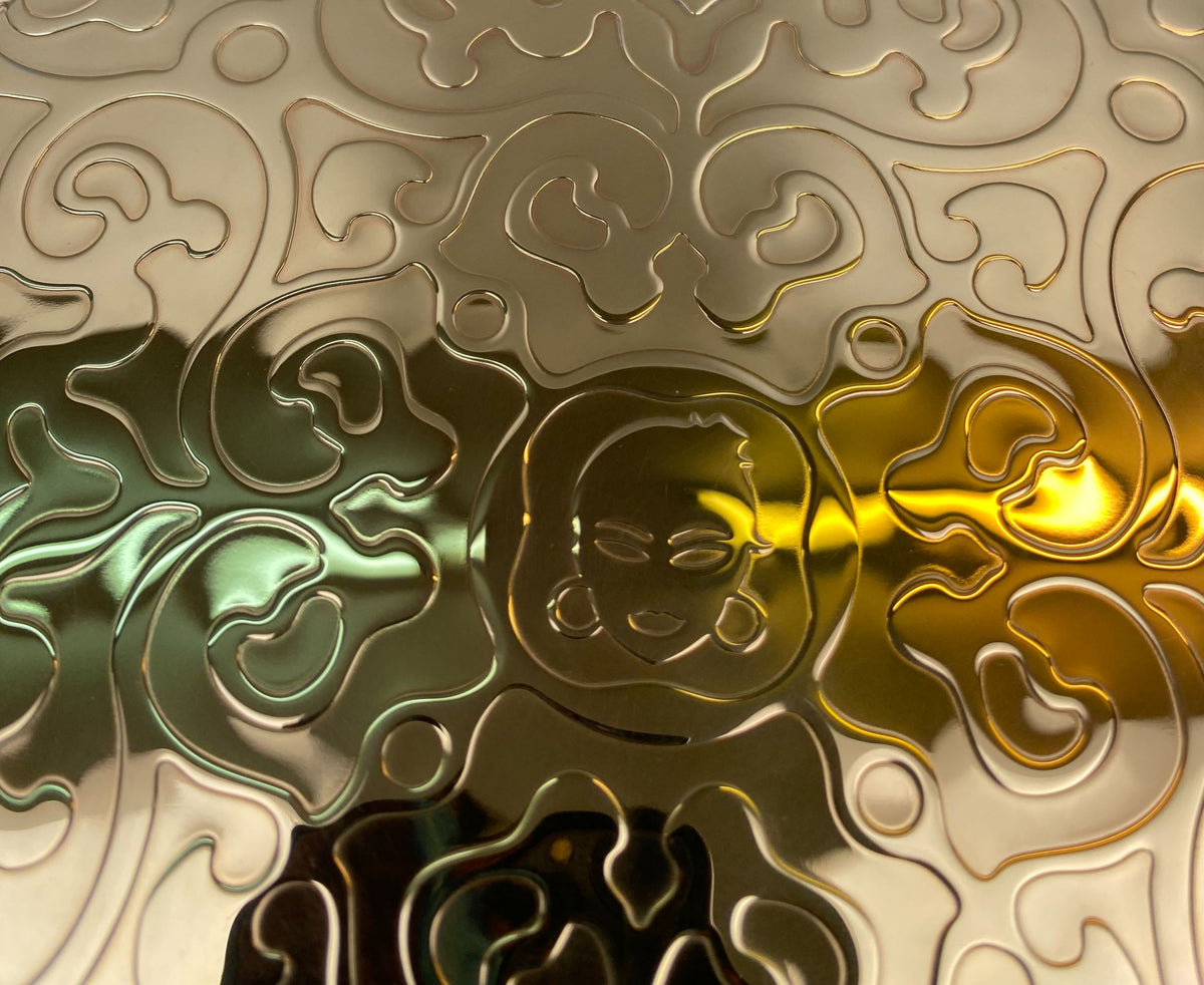 Close-up van het metalen Dressed onderbord met goud reliëf en lichtreflectie