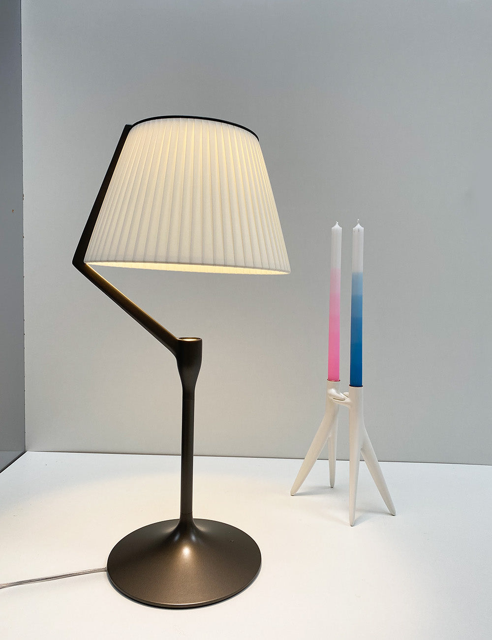 White Abbracciaio candle holder from Kartell next to a table lamp