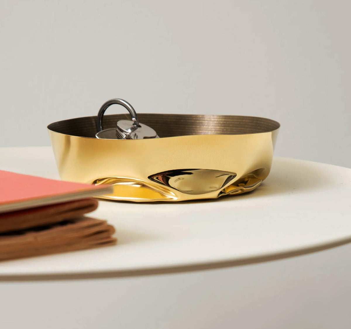 Alessi Compressioni XS mand in messing, gebruikt als sleutelbakje