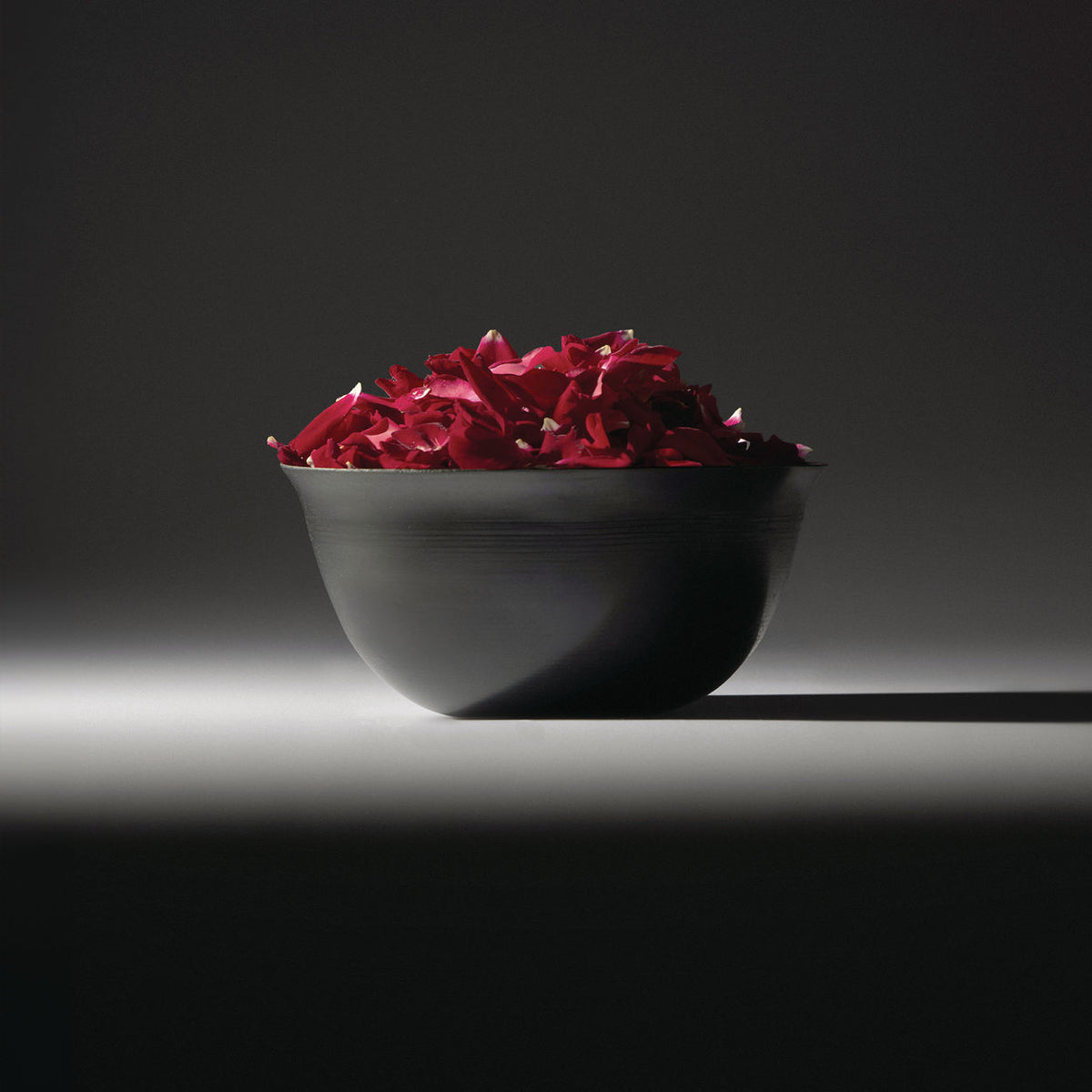 Coppa Camuna bowl in steel, filled with rose petals