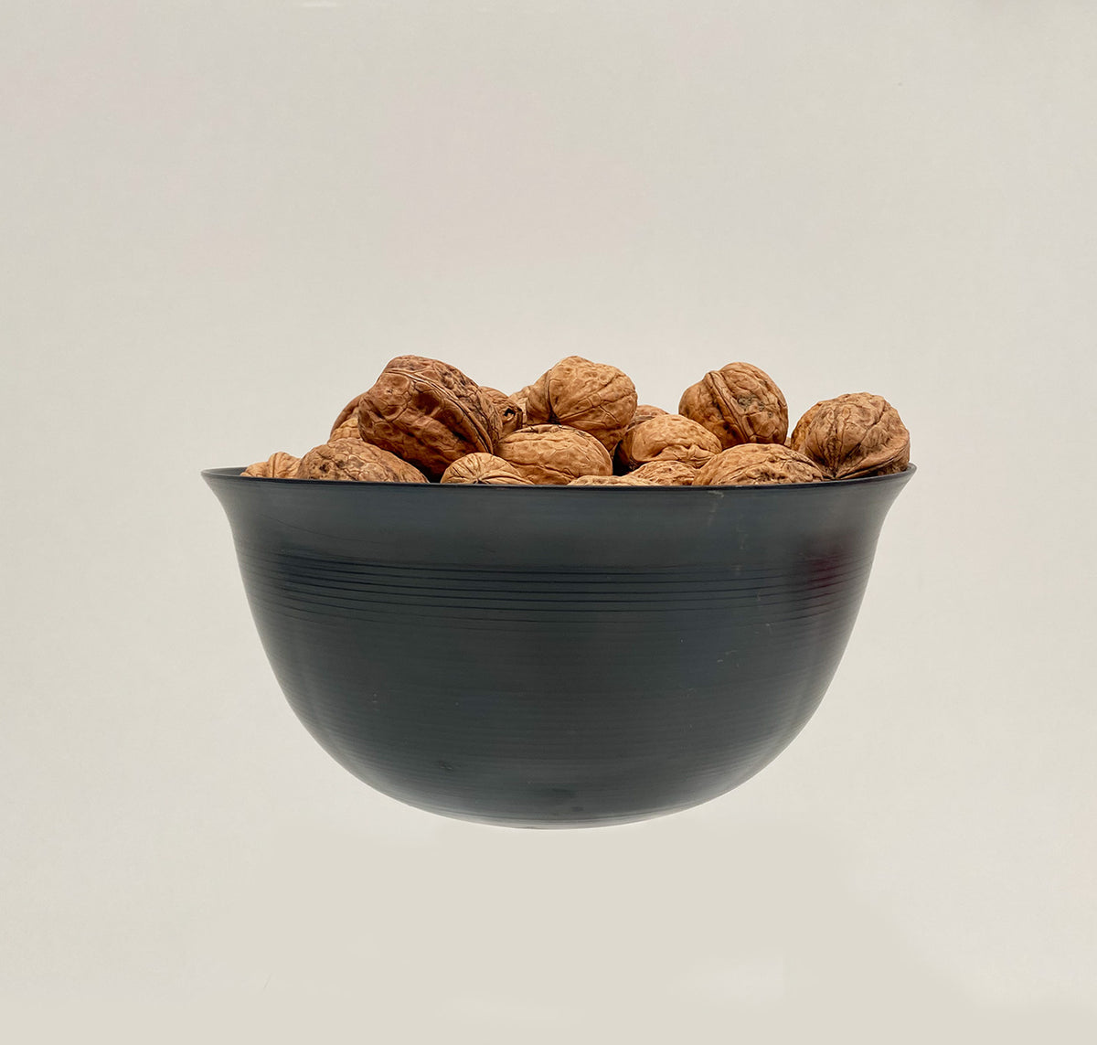 Coppa Camuna steel bowl, side view, filled with walnuts