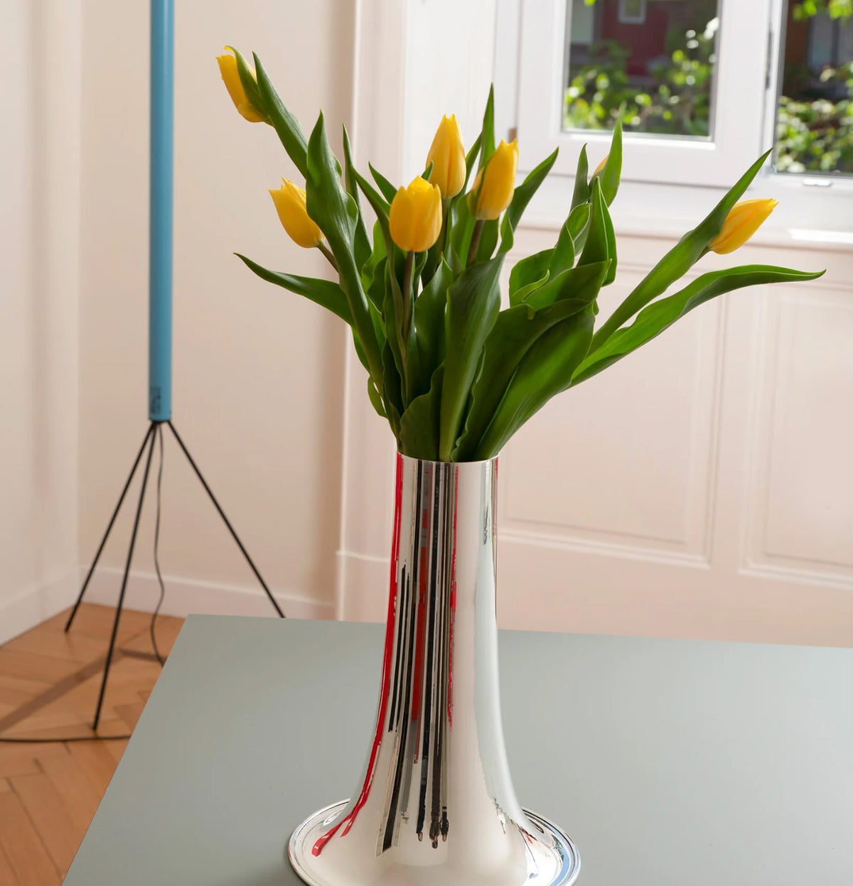 Trumpet vaas breed in zilver van Alessi, met gele tulpen.