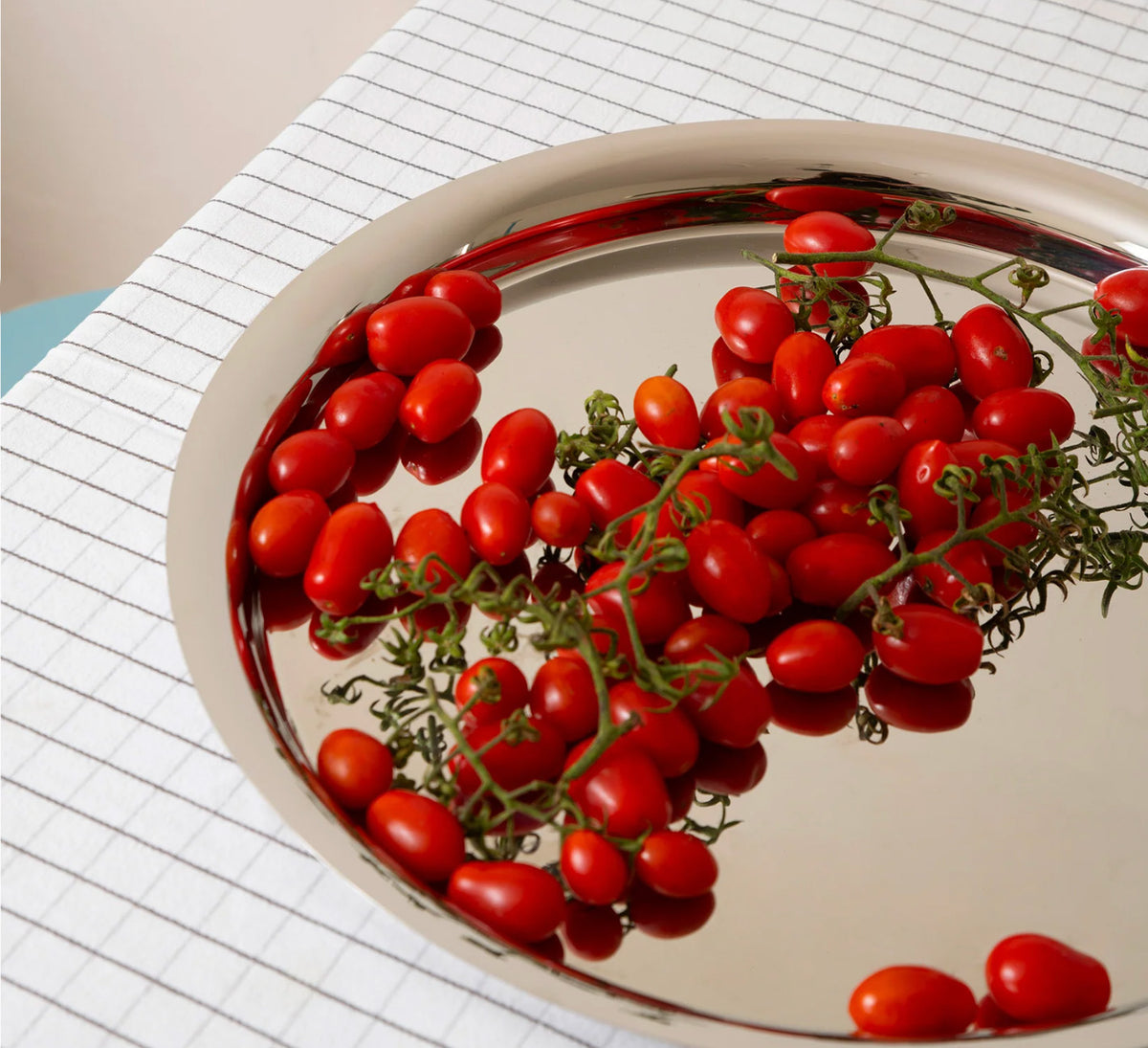 Kuru Kuru dienblad van Alessi gevuld met verse tomaten, bovenaanzicht