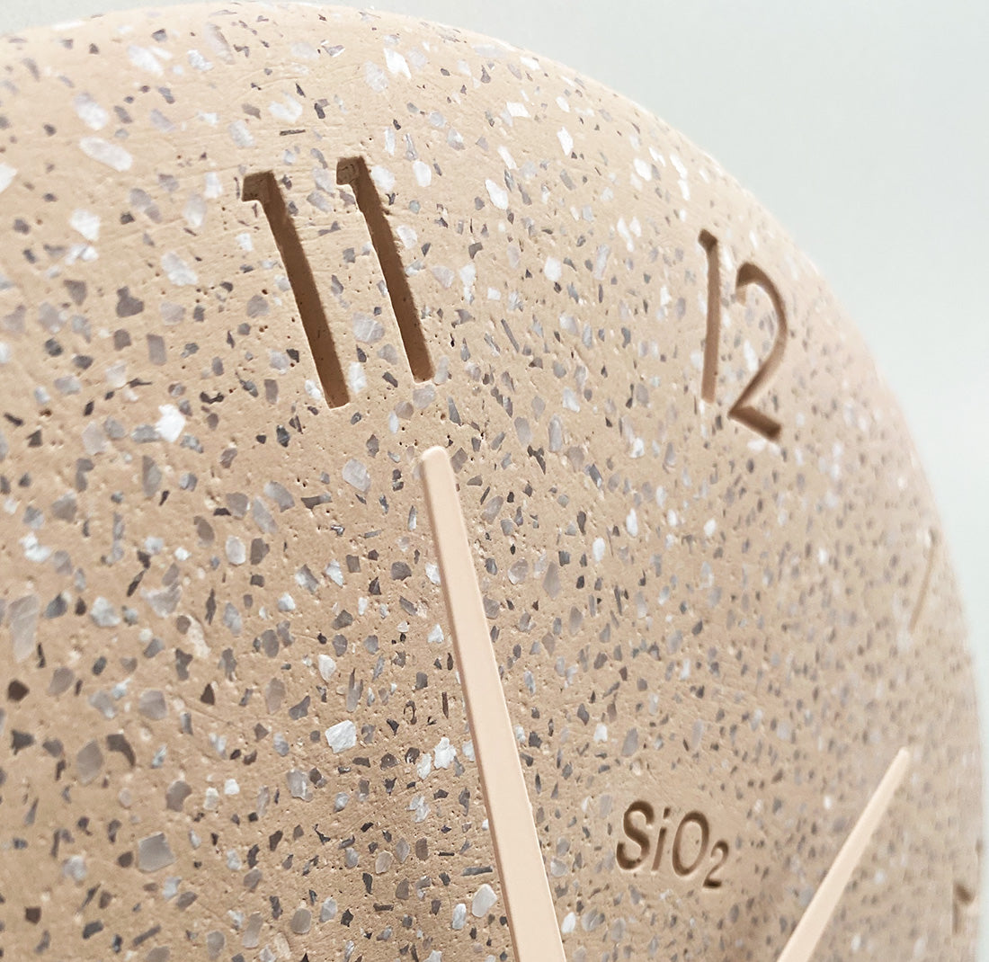 Detail van cijfers en gespikkeld oppervlak van Lemnos SIO2 wandklok in roze