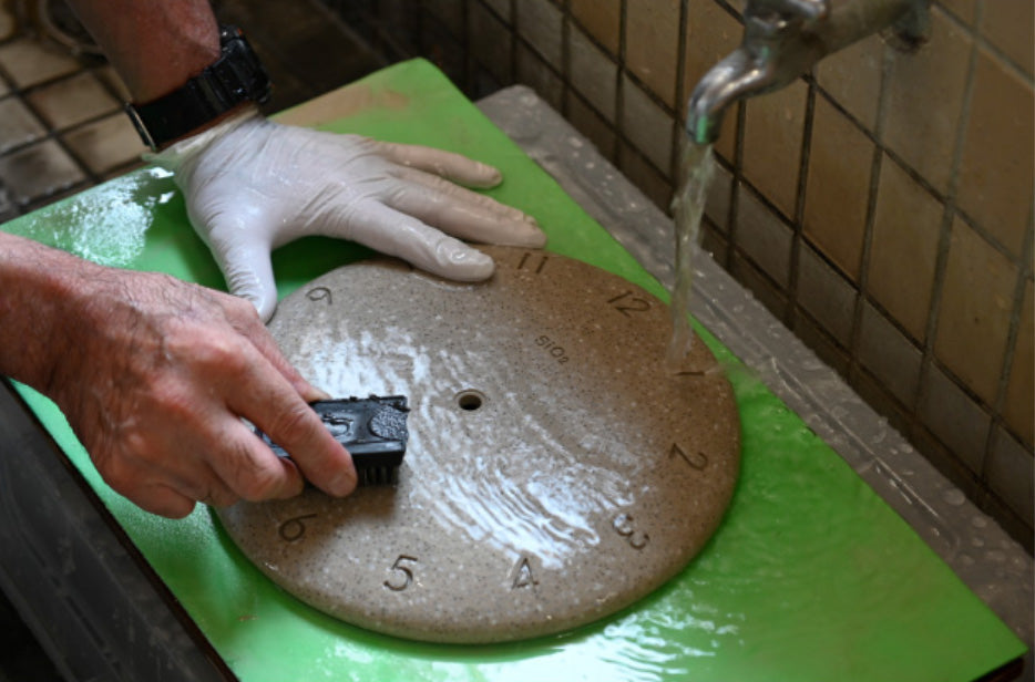 Close-up van de speciale behandeling met water en borstel op de roze wandklok