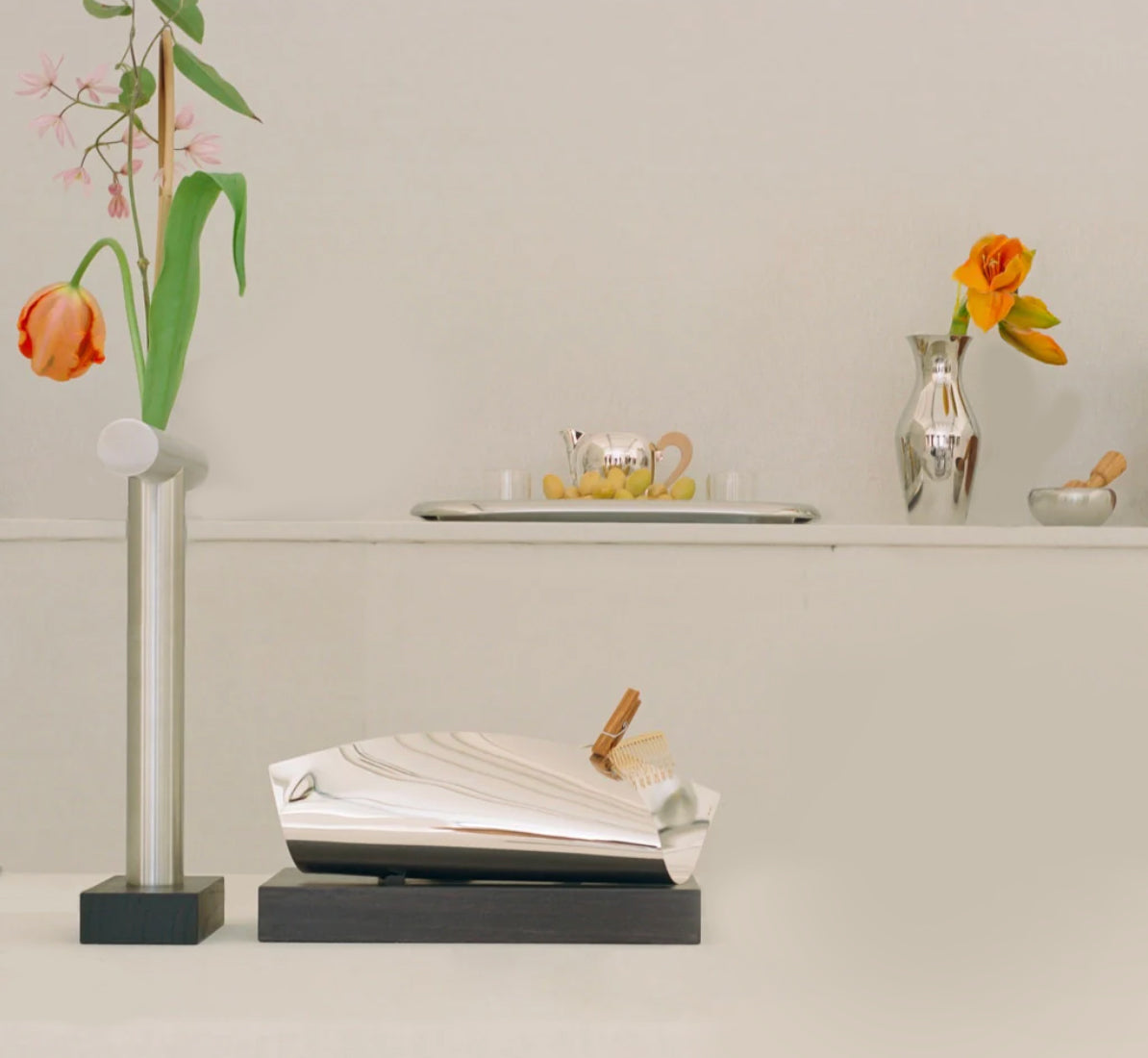 Alessi Tronchetto Nr.44 hoge vaas met bloemtak, in een interieur met andere Alessi objecten