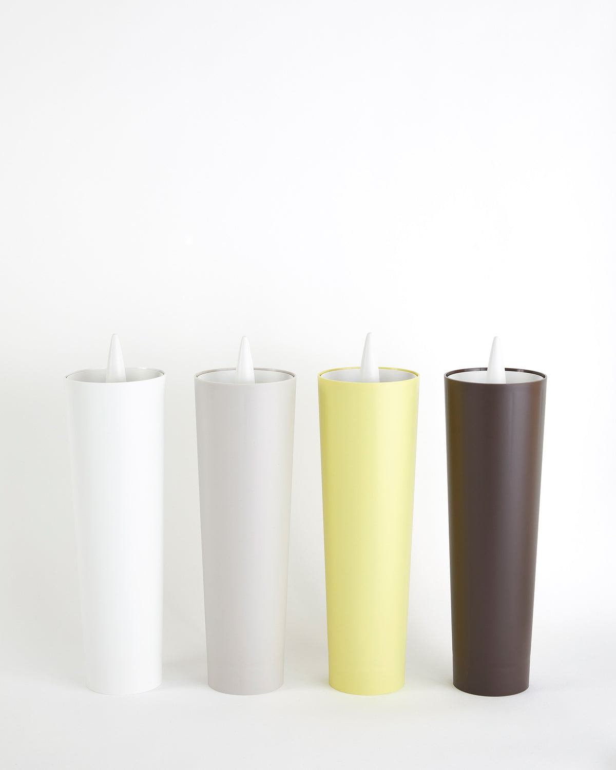 Excalibur toilet brushes in white, grey, yellow and brown side by side