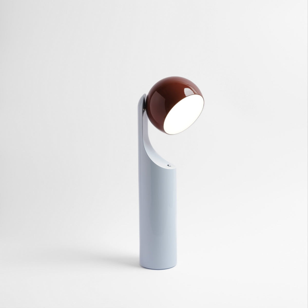 Zijaanzicht Alessi Mono leeslamp, kop 270 graden gedraaid, roestbruin op lichtblauw