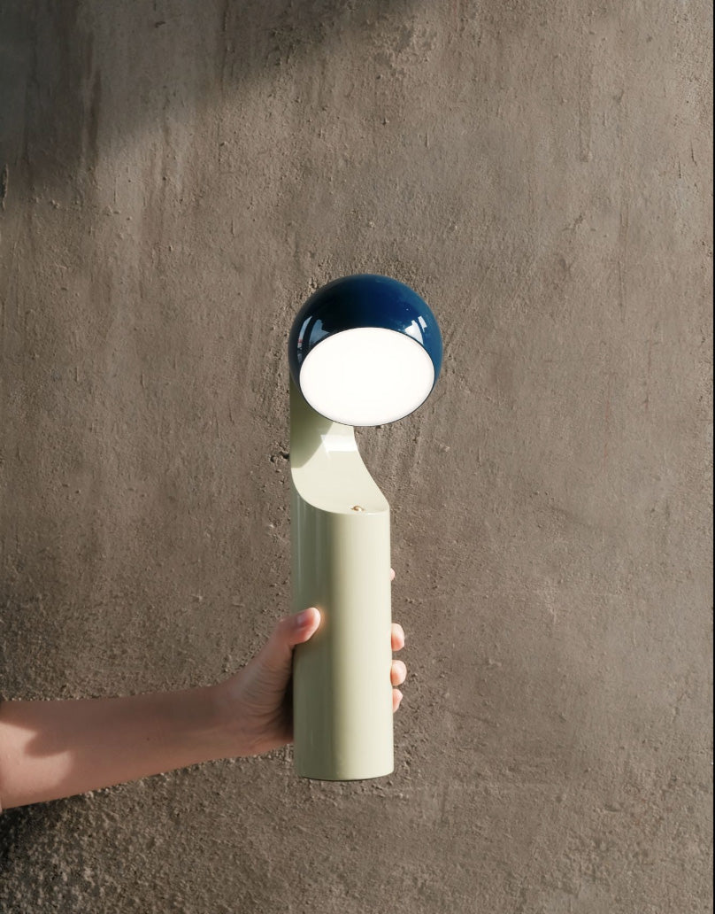 Mono leeslamp in blauw en mint, vastgehouden in een hand