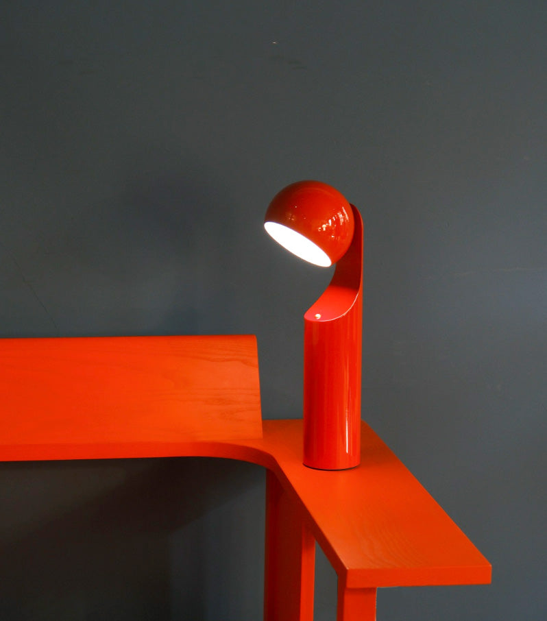 Mono Retro Lamp van Alessi, ontworpen door Notion Studio, in rood met de kop gekanteld.
