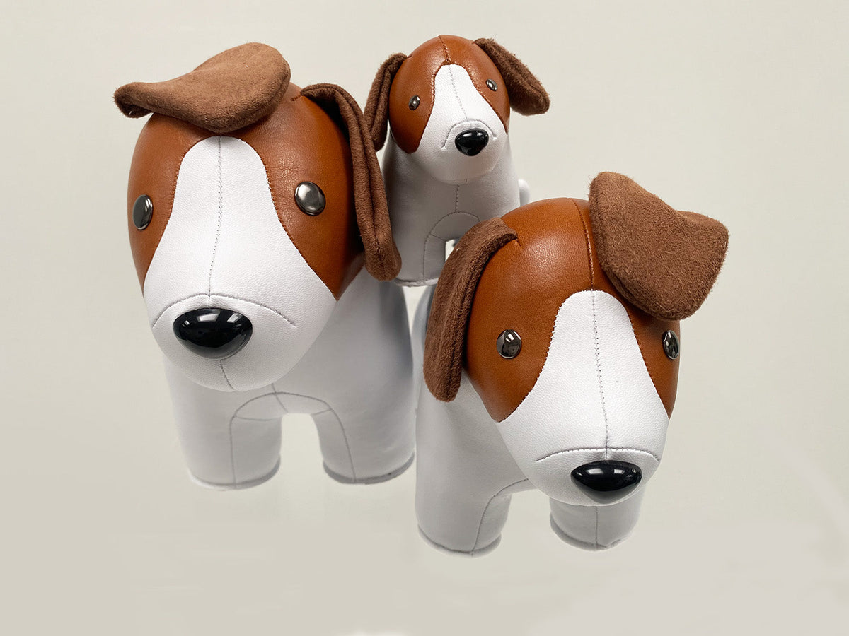 Twee Zuny Beagle presse-papiers in verschillende formaten naast een puppy.