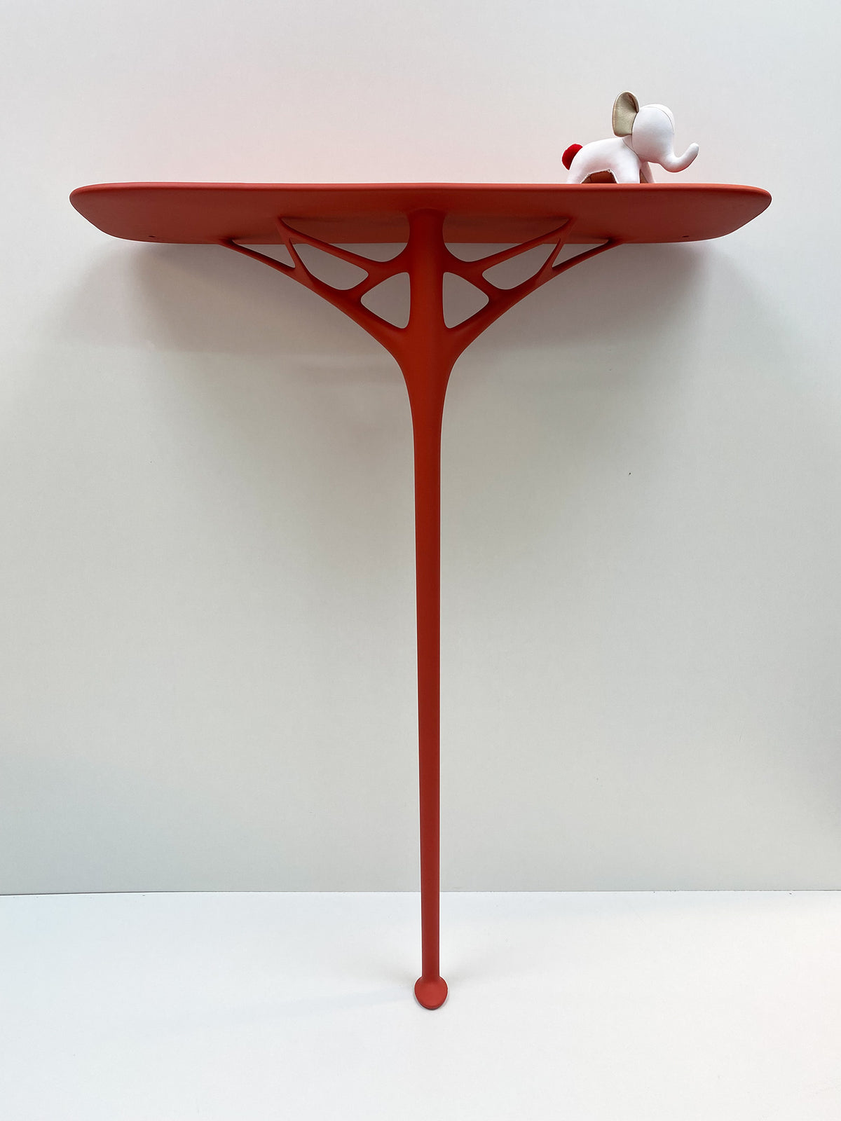 A.I. Console, rode muurtafel van Kartell met olifantfiguurtje op blad