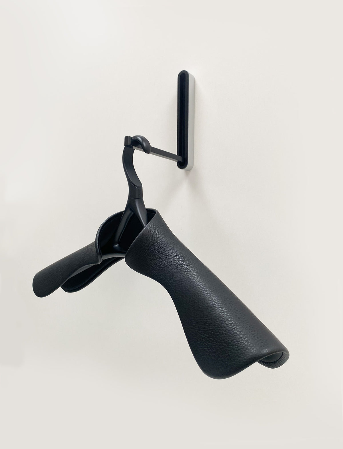 Lou Hansell kledinghanger Jasje H in matzwart-onyx, hangend aan wandhaak