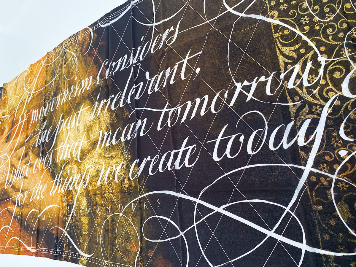 Detail van de sjaal met gouden sierrand en witte calligrafietekst