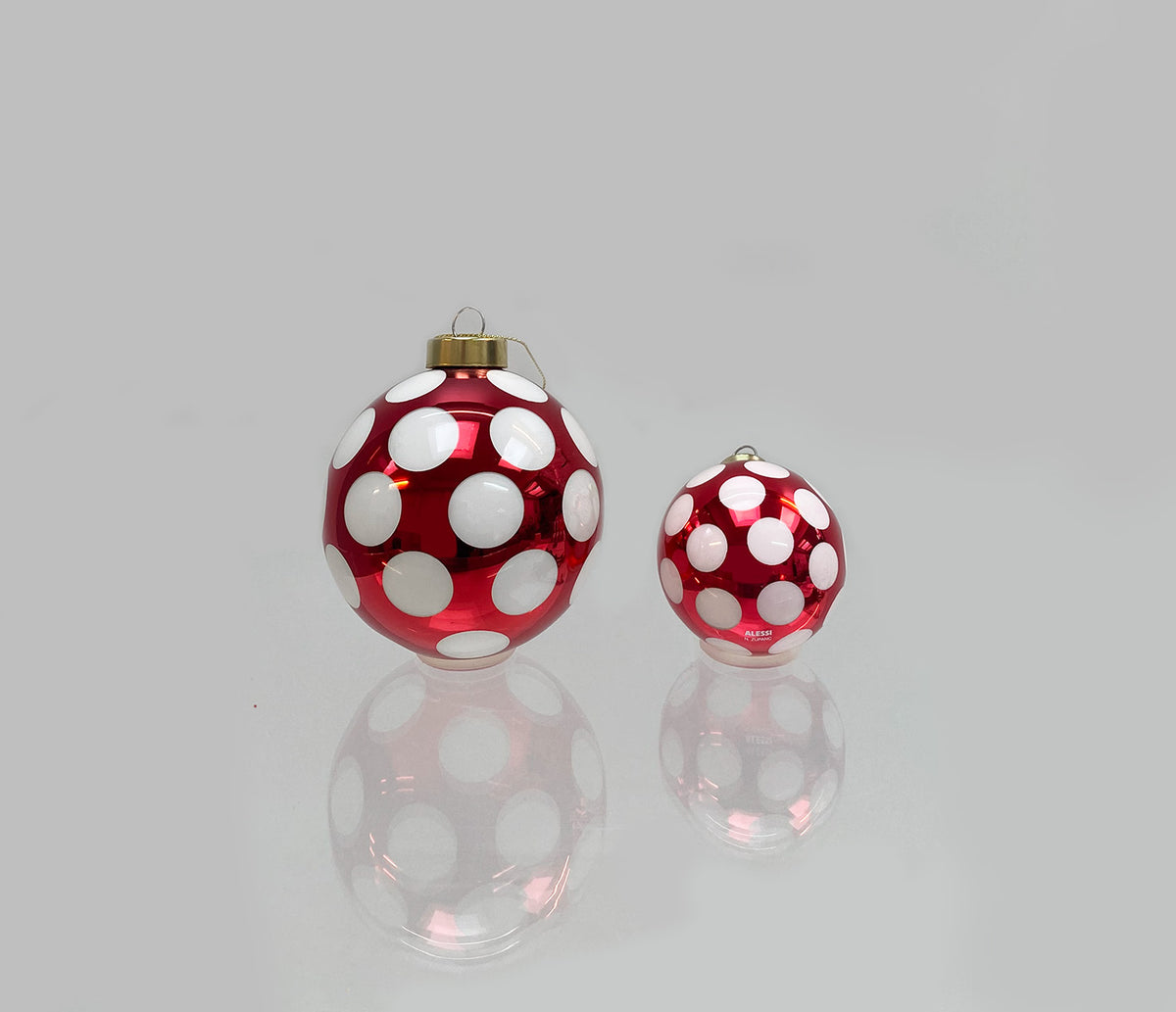 Grote en kleine kerstbal uit de Delight serie naast elkaar, rood met witte stippen