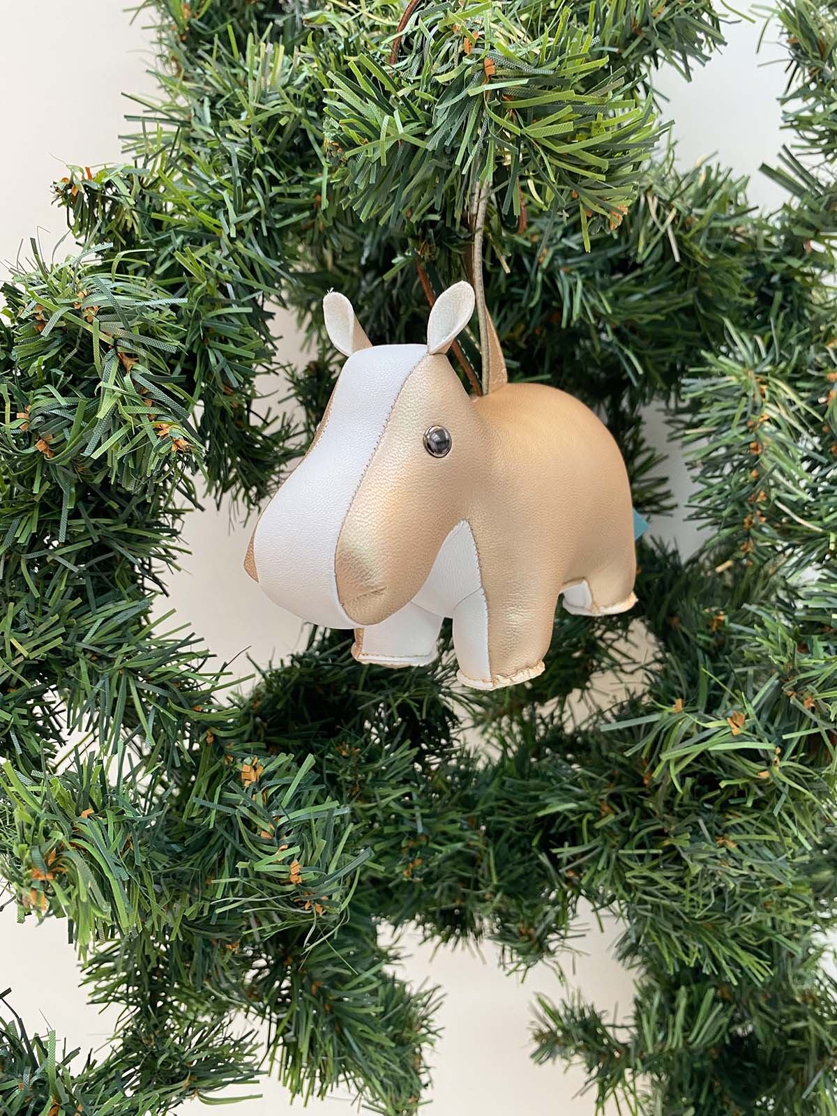 Zuny Mini-Hippo kerstjanger in goud en wit, hangend tussen dennentakken