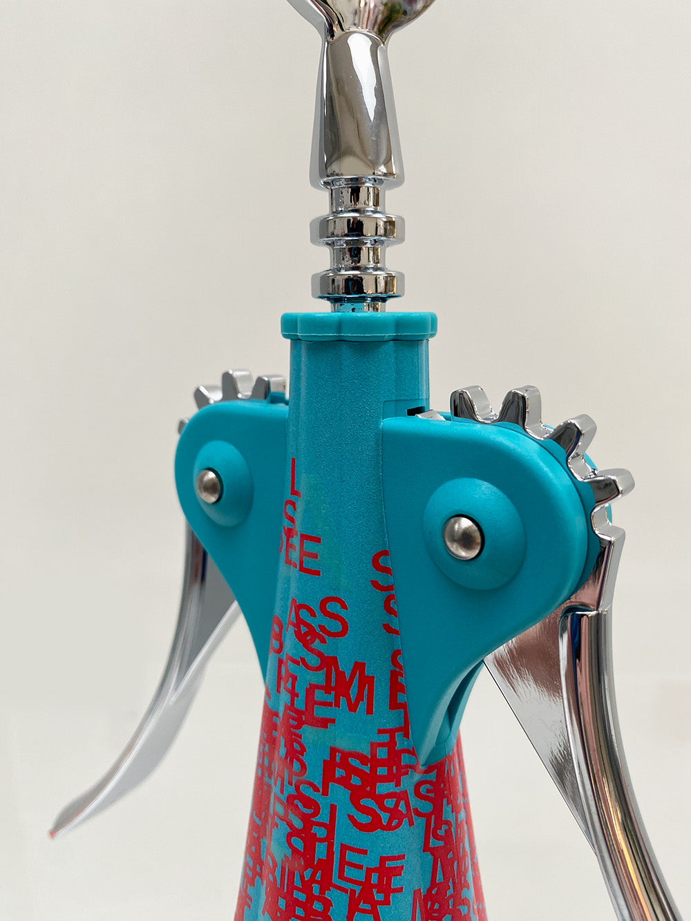 Detail of red low with text motif on Anna Liquid corkscrew
