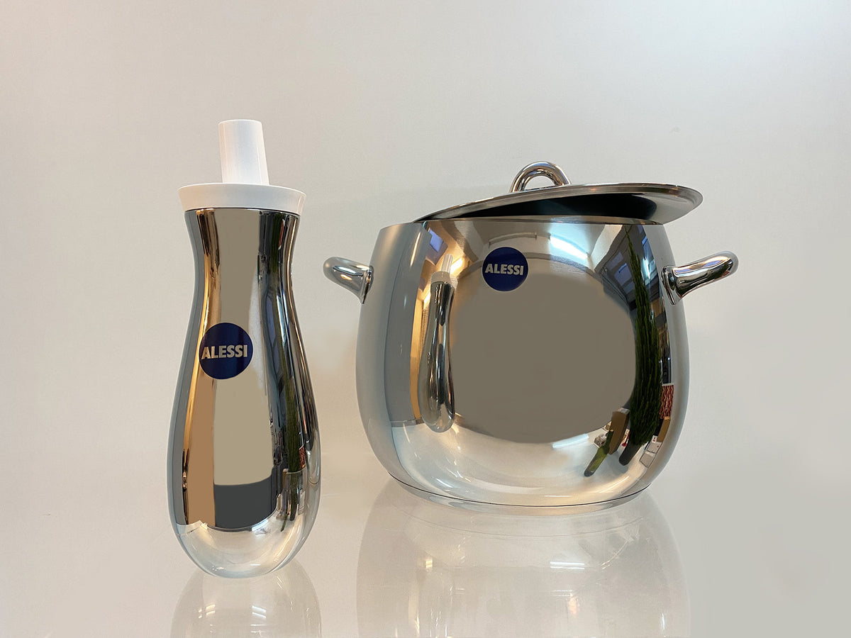 Mami oliefles van Alessi naast Mami kookpan, beide in rvs