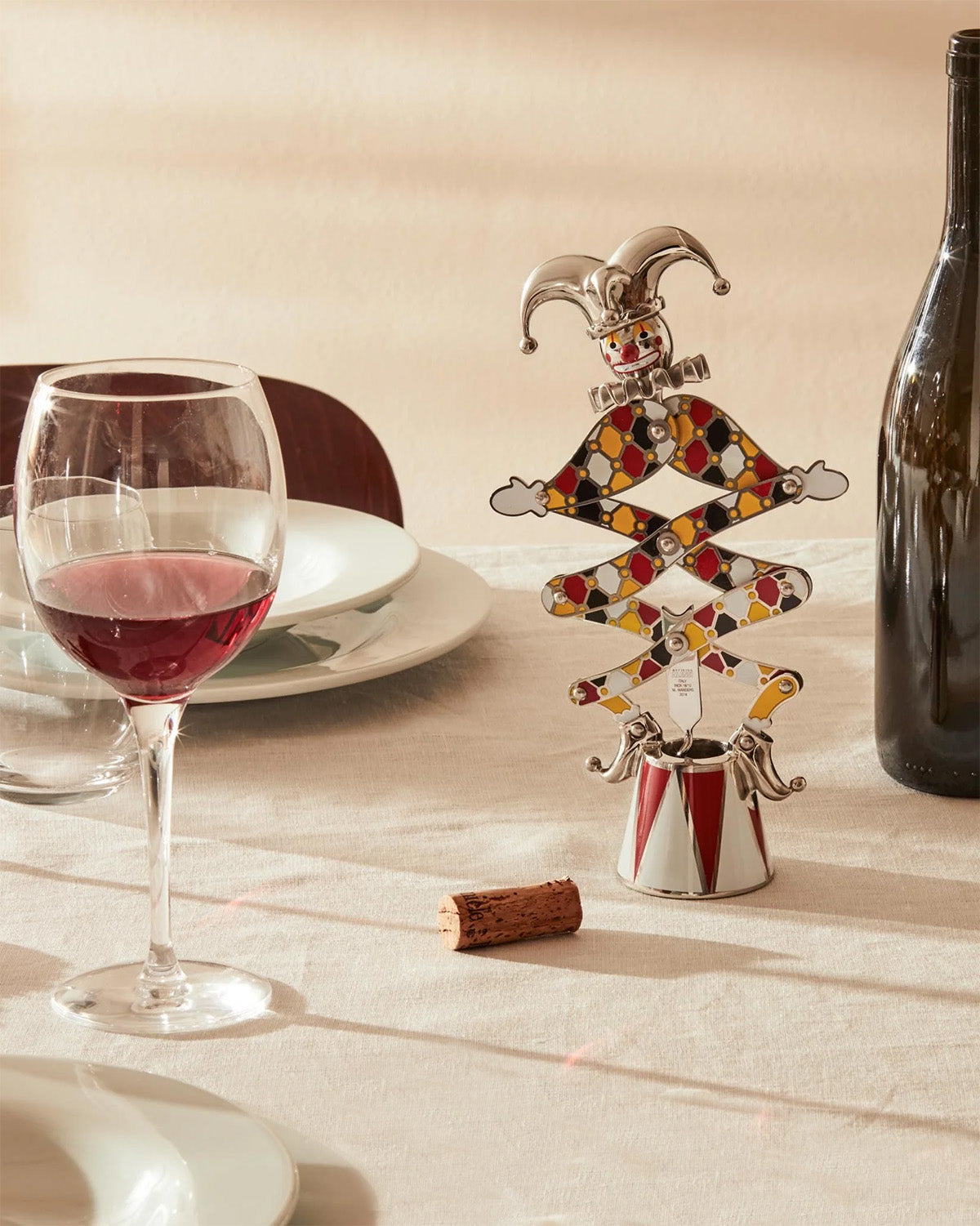 Alessi The Jester kurkentrekker in gebruik naast wijnglas en kurk