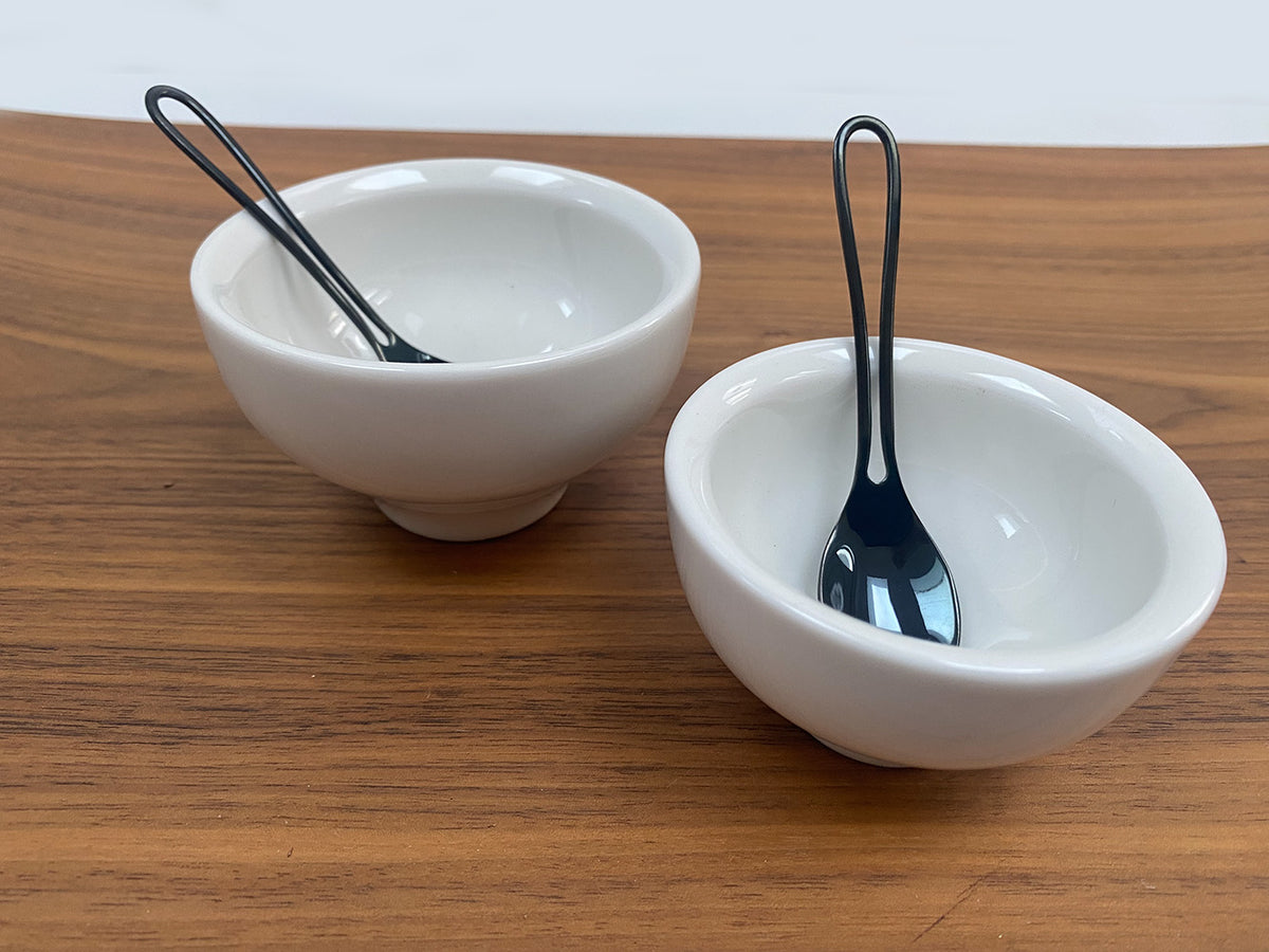Twee Jade espresso koppen van Alessi met zwarte lepels naast elkaar.