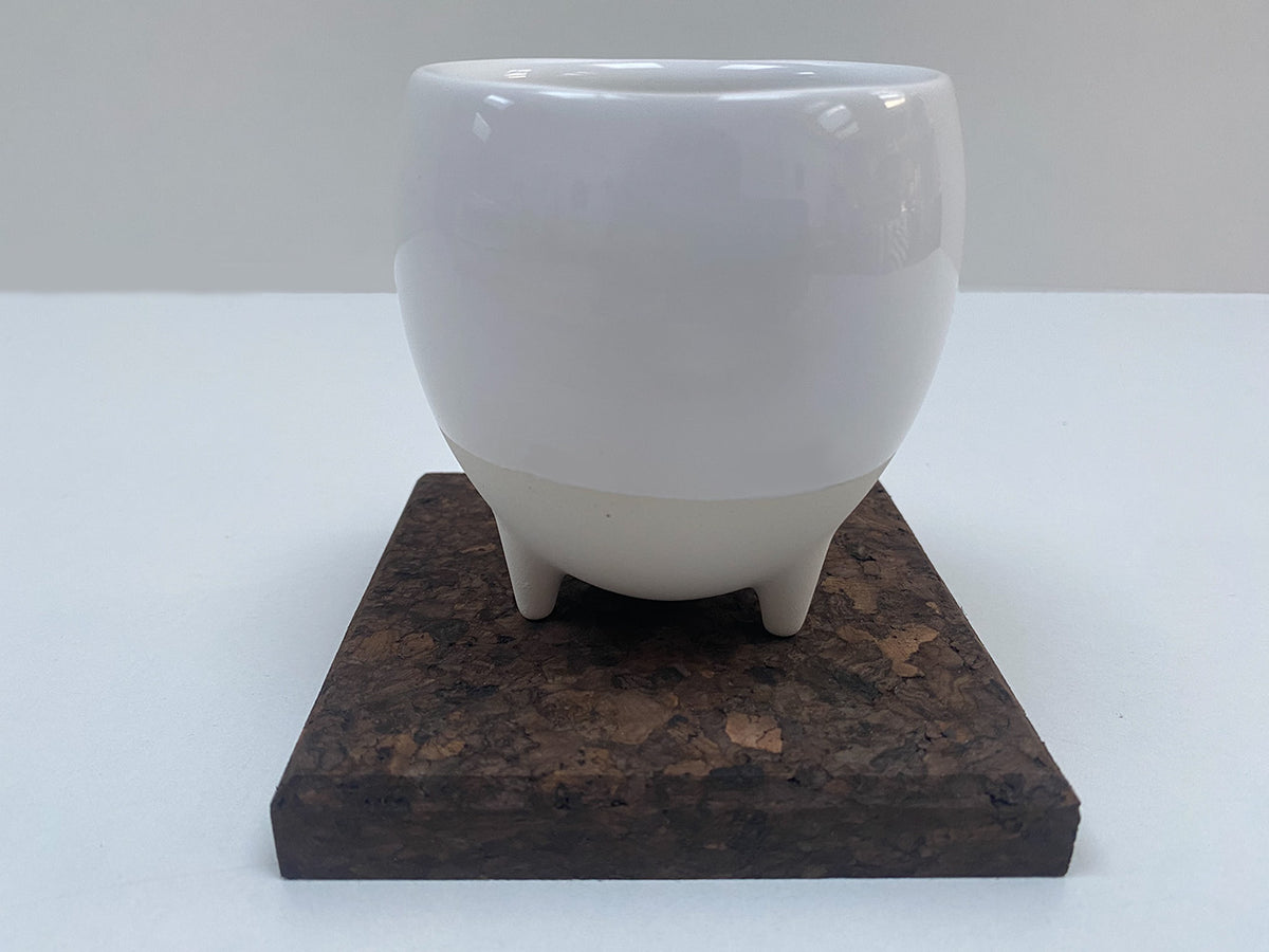 Alessi Egg Coffee Cup op basis met pootjes, geplaatst op kurken onderzetter