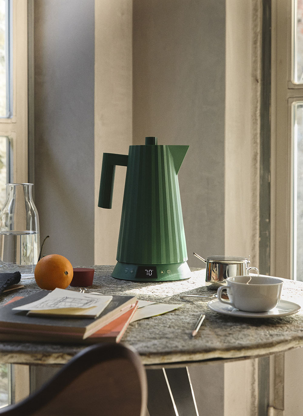 Plissé waterkoker in groen bij het zetten van koffie of thee