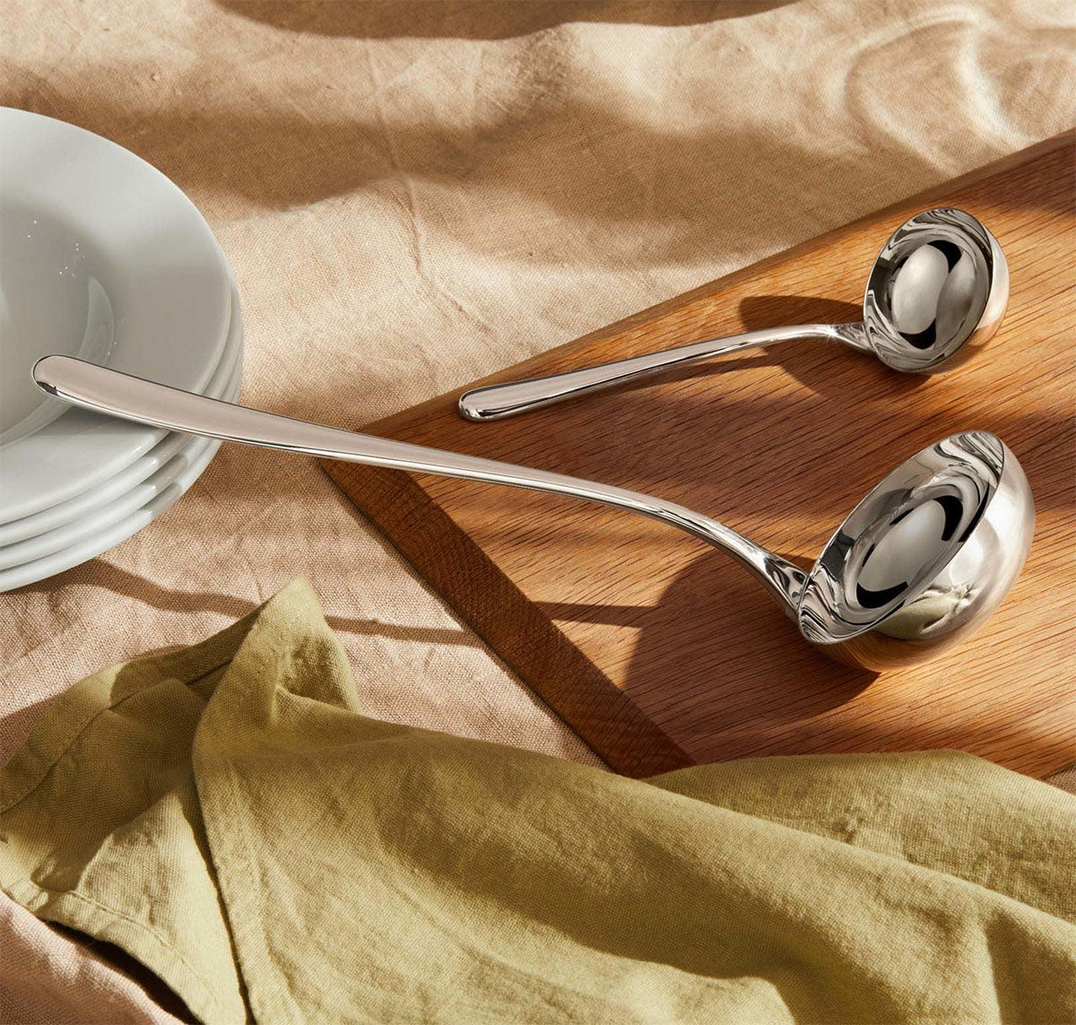 Twee Alessi Caccia sauslepels naast elkaar