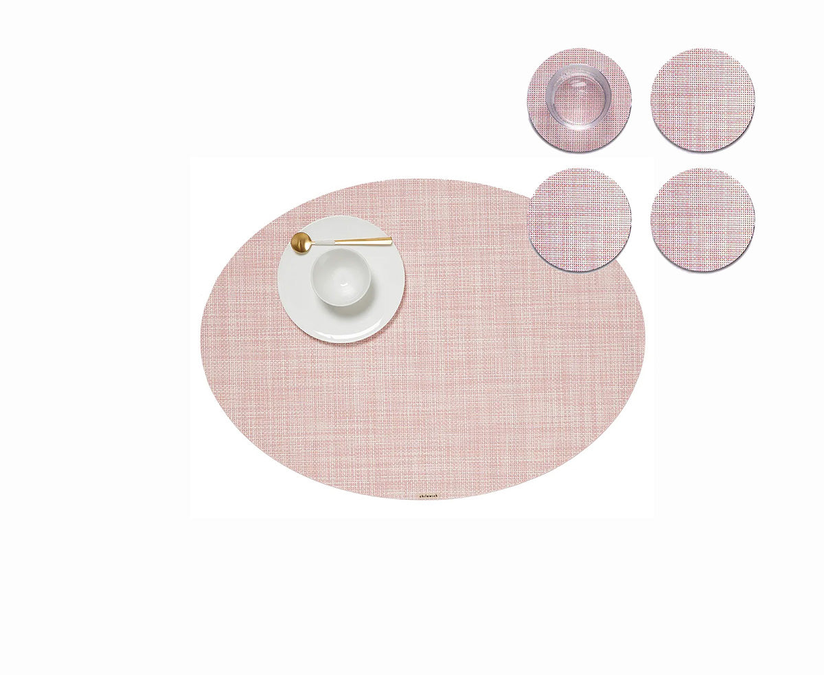 Round coasters in blush next to ovale placemat and plate, design Sandy Chilewich