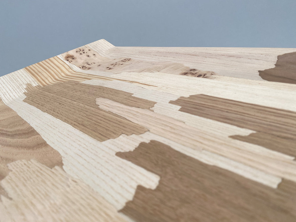 Detail van de houtnerven en het reliëf van het Re-Veneer dienblad van Alessi