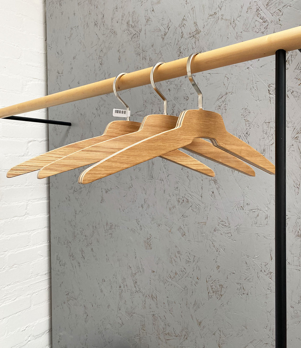 Radius Anzio kledinghangers eiken, drie hangers naast elkaar aan rek