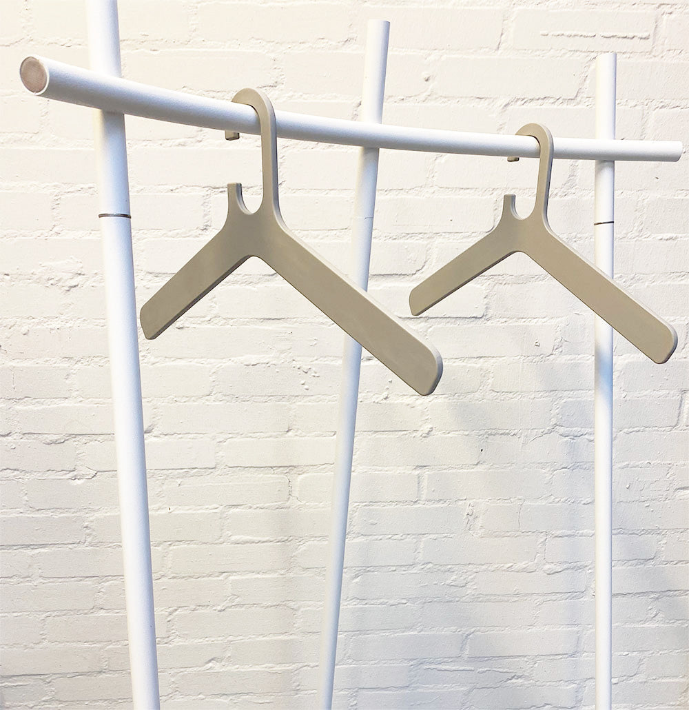 Two grey Grado coat hangers hanging on a clothes rack