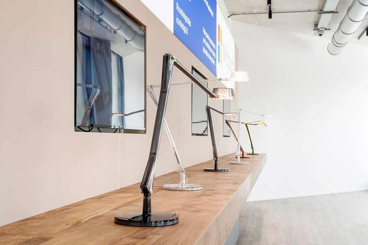 Multiple Aledin desk lamps side by side in a showroom, various colours