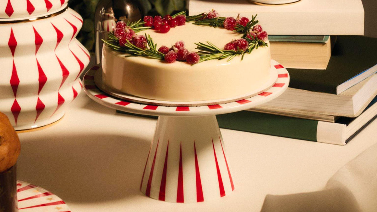 Taartplateau van Alessi, keramiek, met taart en kerstversiering erop.